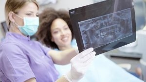 A nurse reviews dental xrays with a patient post implant surgery