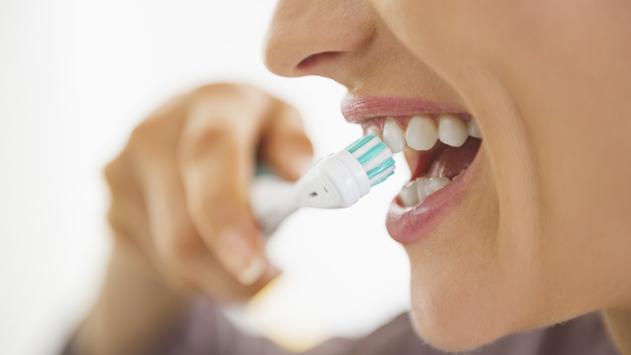 a woman brushes her dental implants